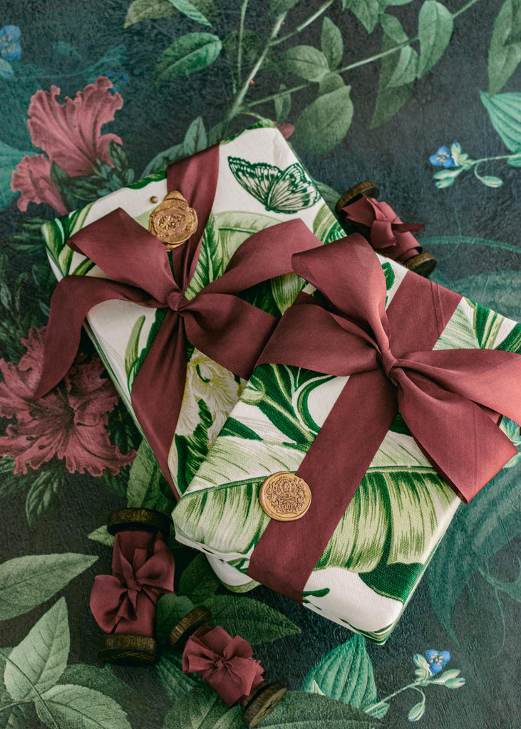 Rich burgundy silk ribbon wrapped around a holiday presents, adding an elegant and timeless touch to Christmas wrapping