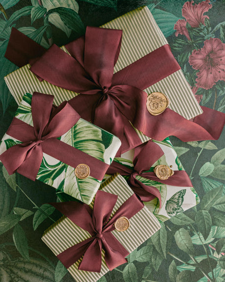 Luxury hand-dyed burgundy silk ribbon arranged with festive styling, perfect for Christmas wrapping details and creative holiday décor
