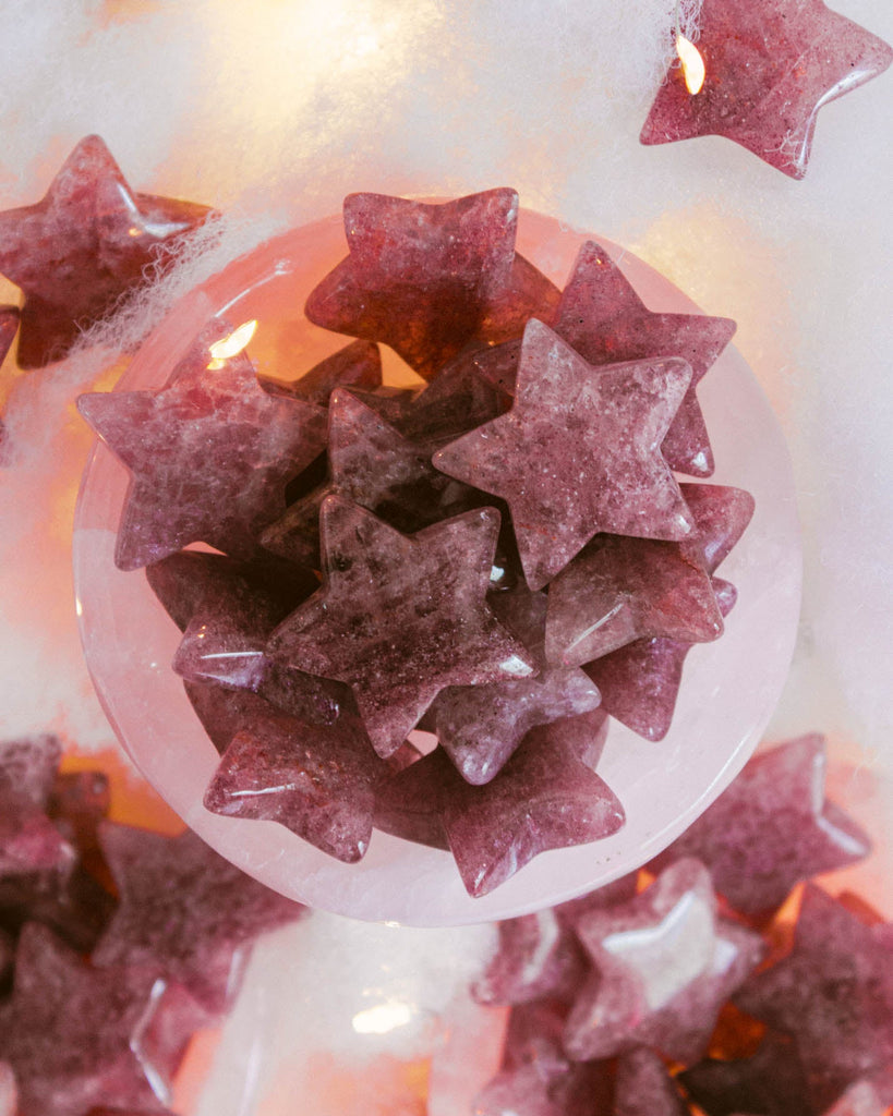 Natural strawberry quartz stars with shimmering berry and blush hues, glowing softly under warm light.