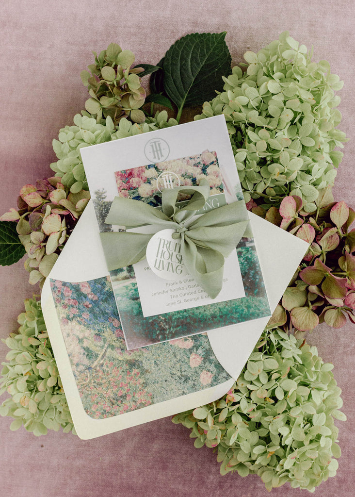 Luxury hand-dyed sage green silk ribbon tied in a bow around wedding invitation, adding a romantic finishing touch