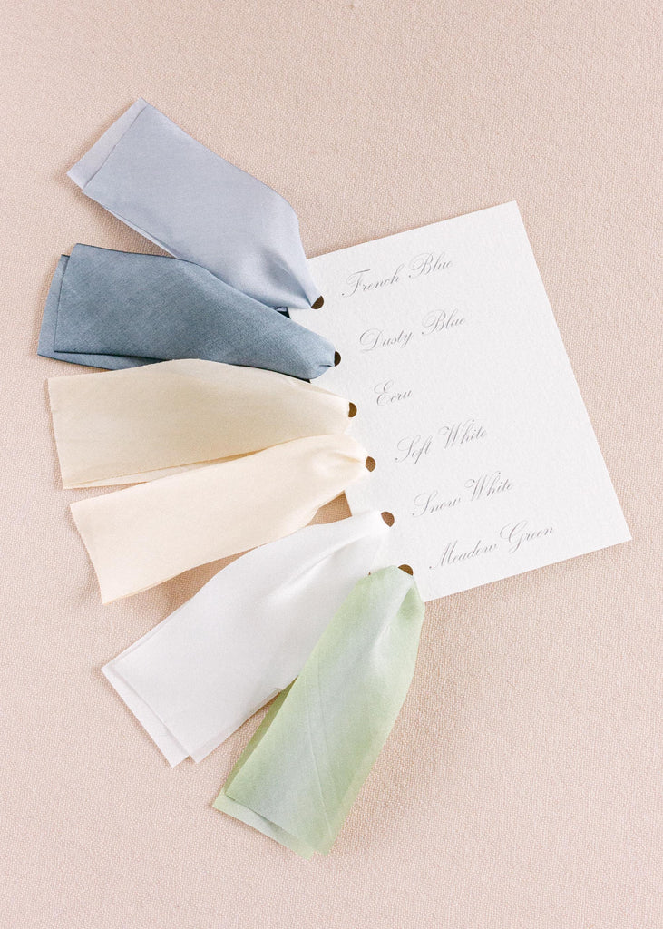Close-up of hand-dyed silk ribbon swatches, displaying a variety of rich colors and the delicate texture of the fabric.