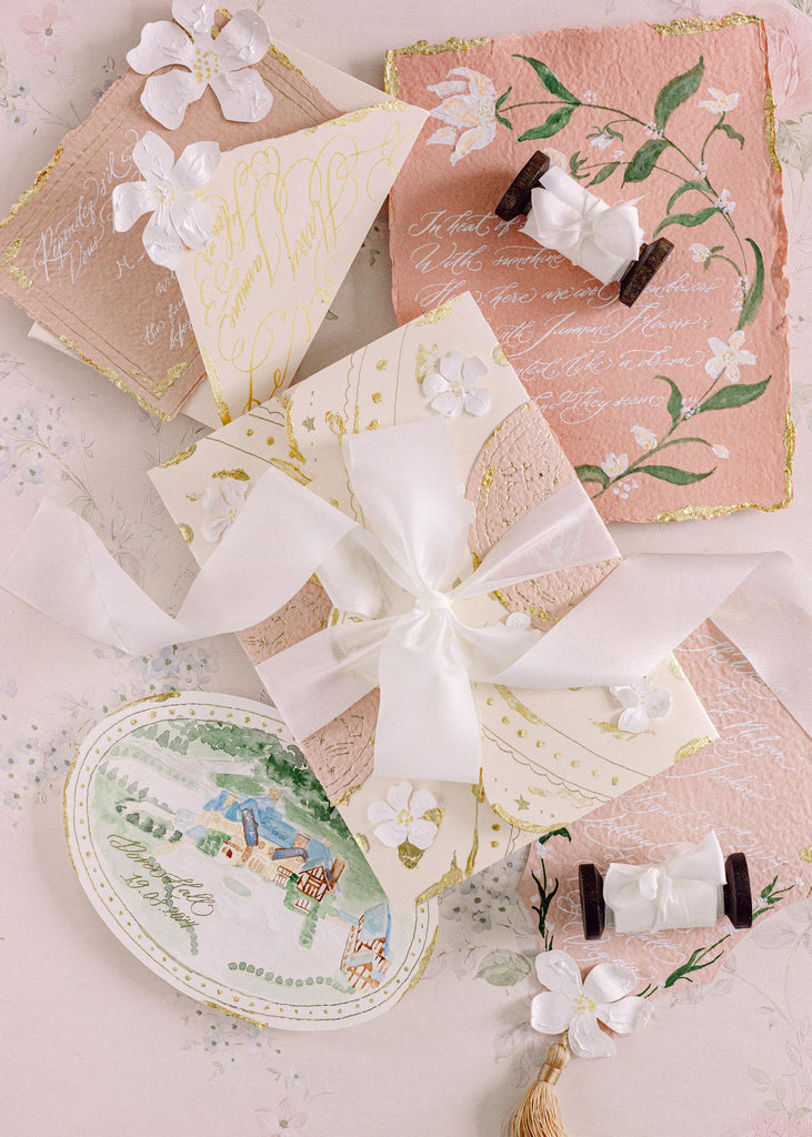 Pure white luxury silk ribbon with wedding invitations tied in a bow.