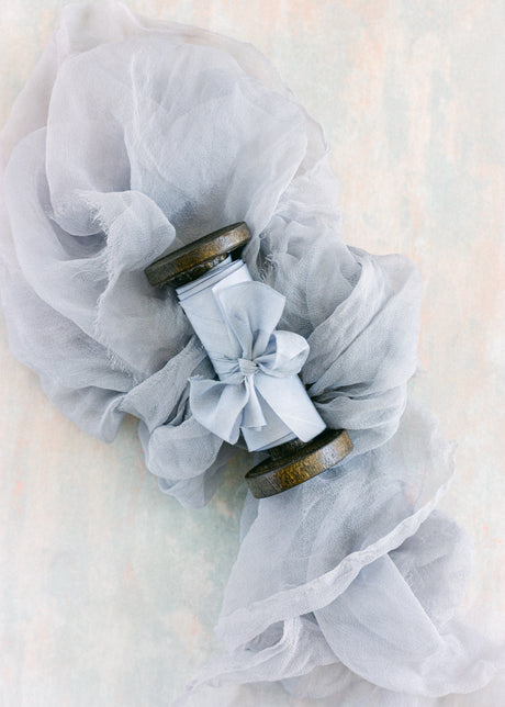 Hand dyed French blue silk ribbon rolled on a wooden spool, perfect for wedding invitations, gift wrapping, and bouquet accents