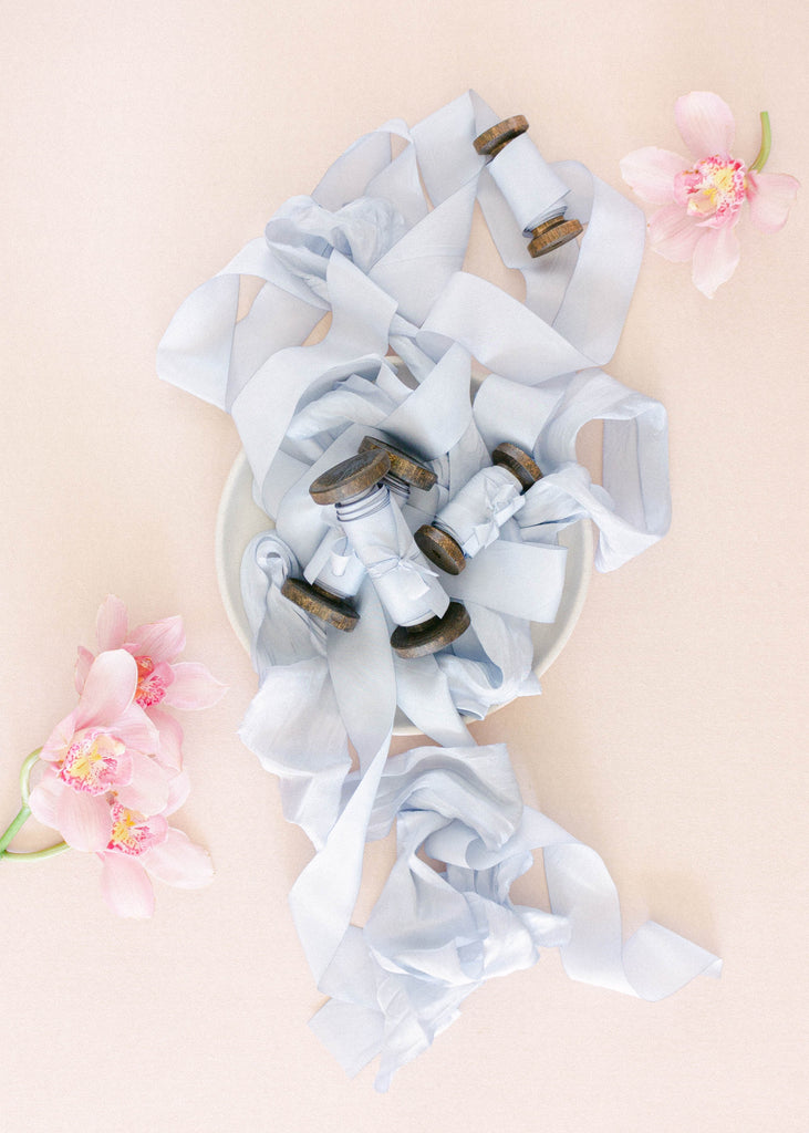 Luxury hand dyed French blue silk ribbon loosely coiled, used for wedding bouquet stems, invitation design, and romantic décor