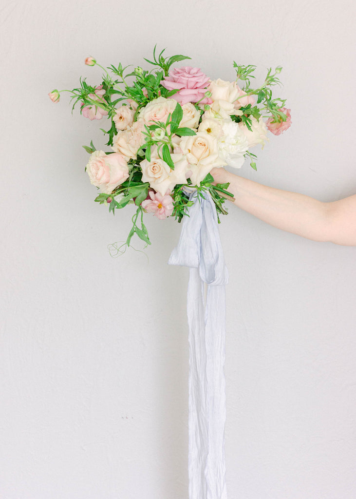 French blue silk ribbon tied in a soft bow around a wedding bouquet, also ideal for invitations and event details